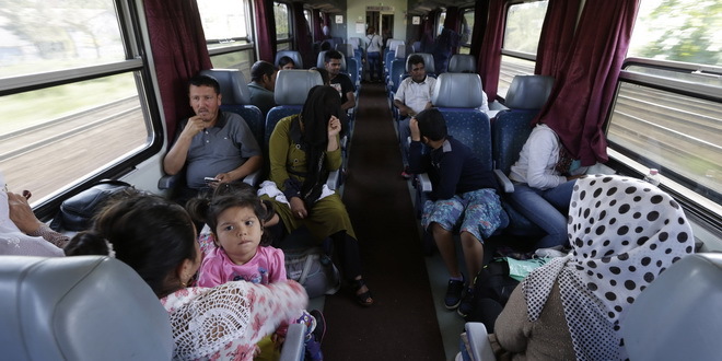 People sit on a train as hundreds of migrants left the Keleti Railway Station in Budapest, Hungary, Thursday, Sept. 3, 2015. Over 150,000 migrants have reached Hungary this year, most coming through the southern border with Serbia. Many apply for asylum but quickly try to leave for richer EU countries. (AP Photo/Petr David Josek)